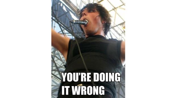 Ein Sänger mit einem Mikrofon im Mund auf einer Bühne.