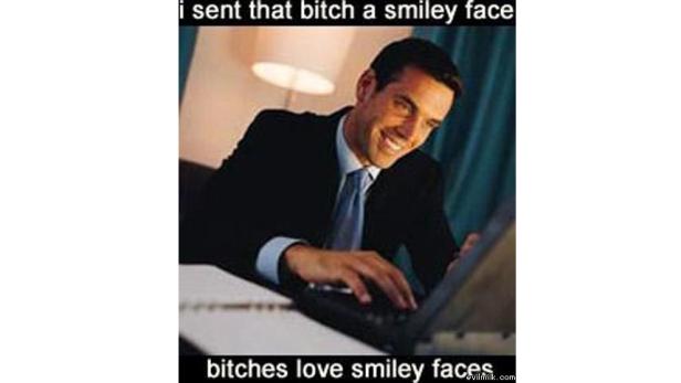 Ein lächelnder Mann im Anzug tippt auf einem Laptop.