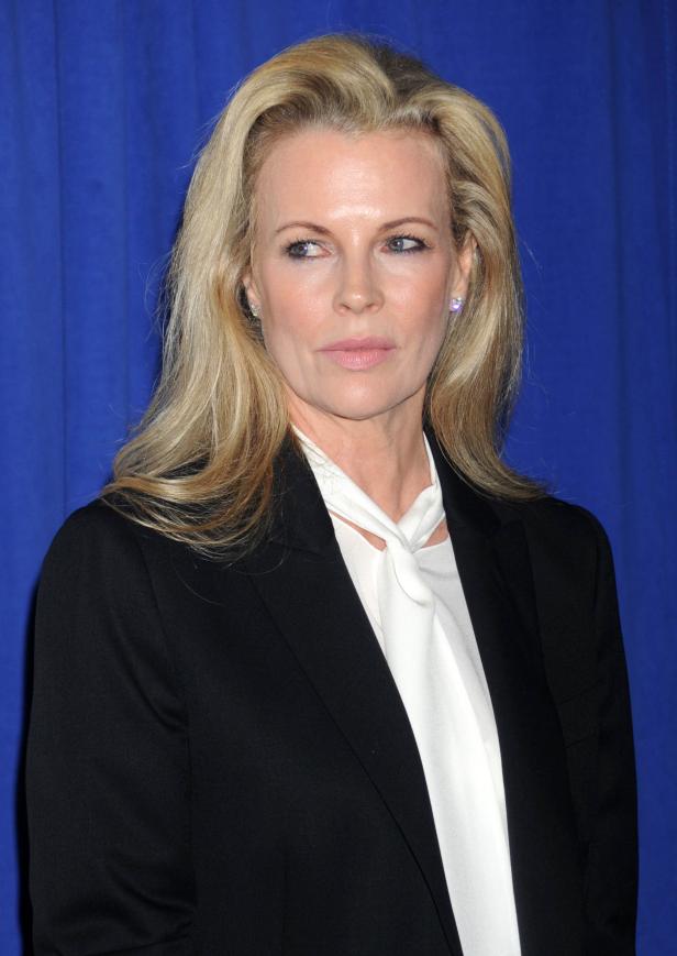 Kim Basinger vor einem blauen Hintergrund.