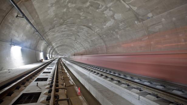 Ein Zug fährt mit hoher Geschwindigkeit durch einen Betontunnel.