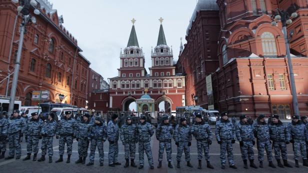 Eine Reihe von Polizisten in Tarnuniform steht auf dem Roten Platz in Moskau.