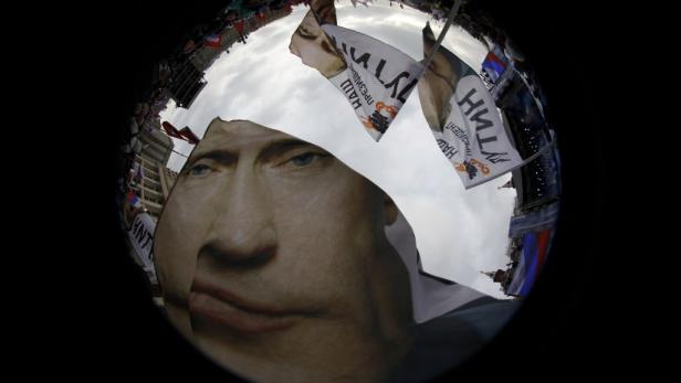 Ein Fischaugenblick zeigt eine Demonstration mit Putin-Porträts und russischen Flaggen.