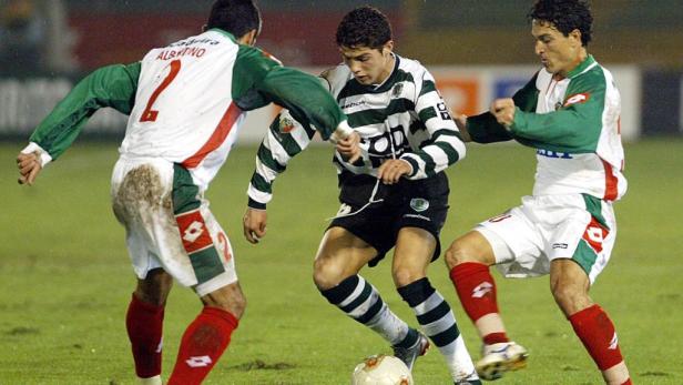 Cristiano Ronaldo dribbelt im Trikot von Sporting Lissabon gegen zwei Gegenspieler.