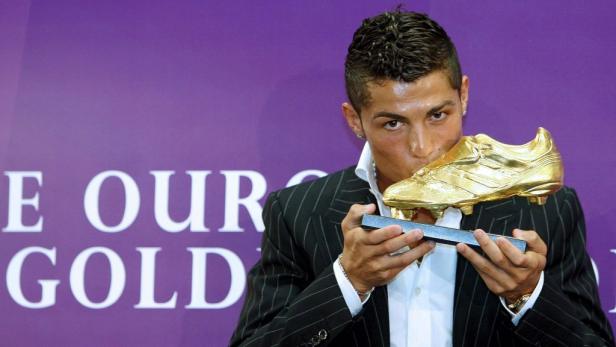 Cristiano Ronaldo küsst einen goldenen Schuh.