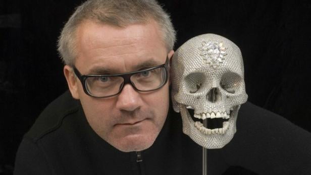 Damien Hirst posiert neben seinem mit Diamanten besetzten Schädelkunstwerk.