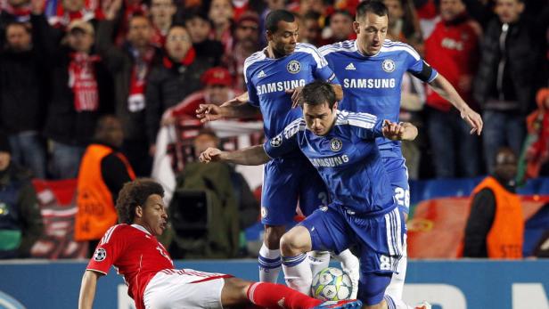 Ein Fußballspieler von Bayern München grätscht vor drei Chelsea-Spielern nach dem Ball.