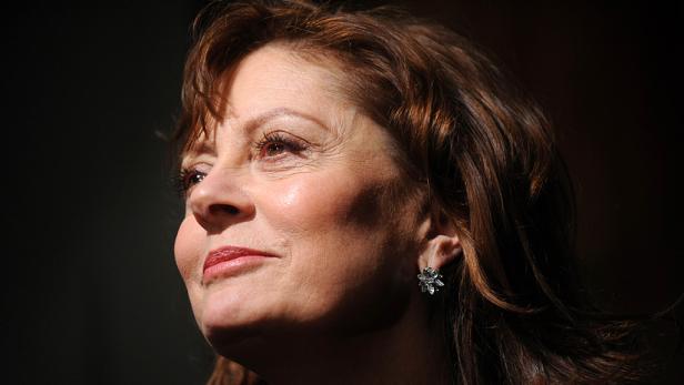 Ein Porträt von Susan Sarandon mit braunen Haaren und Ohrringen.