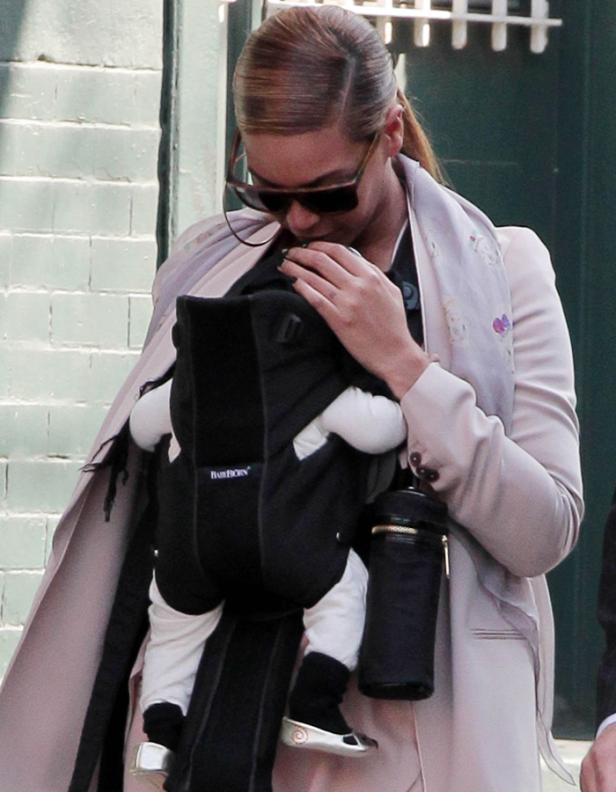 Beyoncé trägt ihr Kind in einer Babytrage.