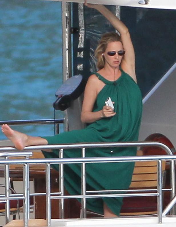 Uma Thurman dehnt sich barfuß an Bord einer Yacht.