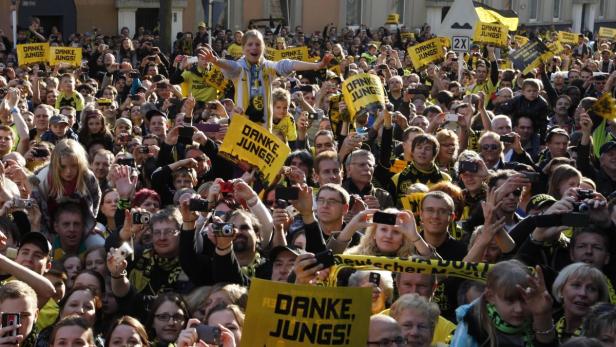Eine große Menschenmenge, viele mit Borussia Dortmund-Schals und „Danke, Jungs!“-Schildern.