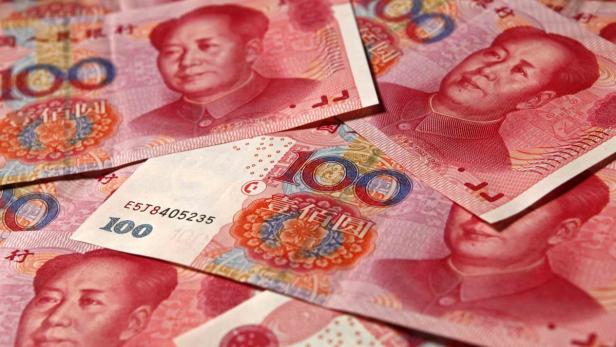 Mehrere 100-Yuan-Banknoten der chinesischen Währung Renminbi liegen übereinander.