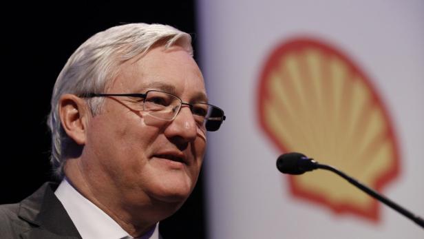 Ein Mann mit Brille spricht vor einem Mikrofon, im Hintergrund das Shell-Logo.