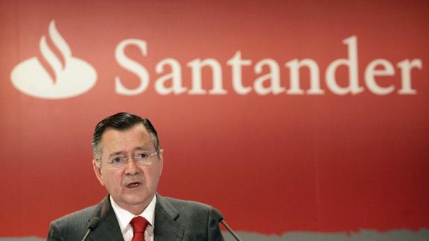 Ein Mann spricht vor einem roten Hintergrund mit dem Santander-Logo.