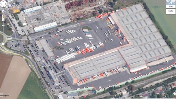 Luftaufnahme eines großen Logistikzentrums mit vielen LKWs und Parkplätzen.