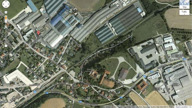 Eine Luftaufnahme von Kremsmünster, Österreich, mit Fabriken, Wohnhäusern und Schloss Kremssegg.
