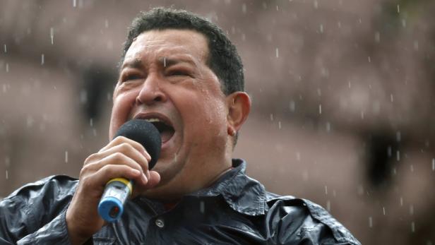 Hugo Chávez spricht während eines Regenschauers in ein Mikrofon.