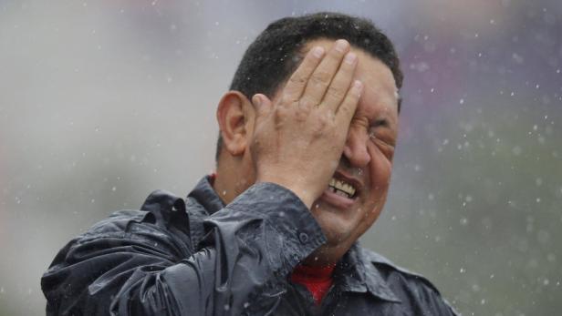 Ein Mann schützt sein Gesicht vor dem Regen.