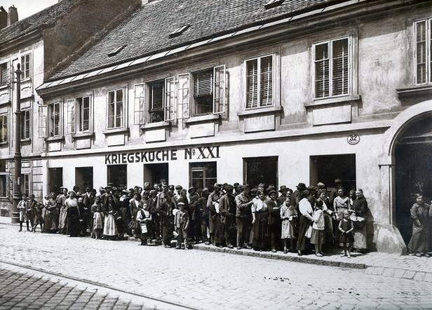 Eine Menschenmenge steht vor einer „Kriegsküche No. XXI“ in einem historischen Gebäude.