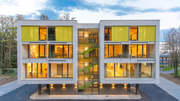 Neues Kinderhilfshaus in Graz Ein modernes, mehrstöckiges Gebäude mit großen Fenstern und gelben Akzenten.