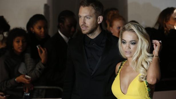 Calvin Harris und Rita Ora posieren zusammen auf dem roten Teppich.
