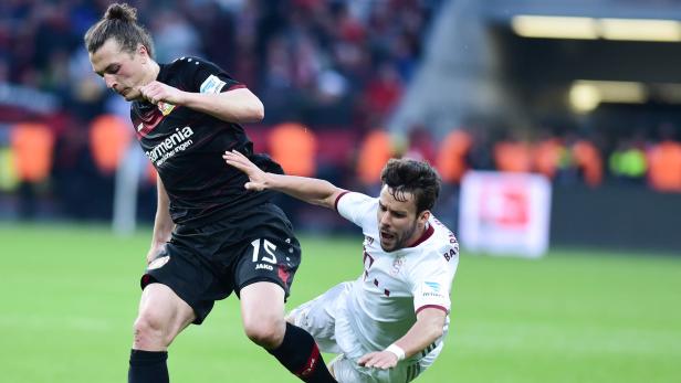 Zwei Fußballspieler kämpfen um den Ball während eines Spiels.