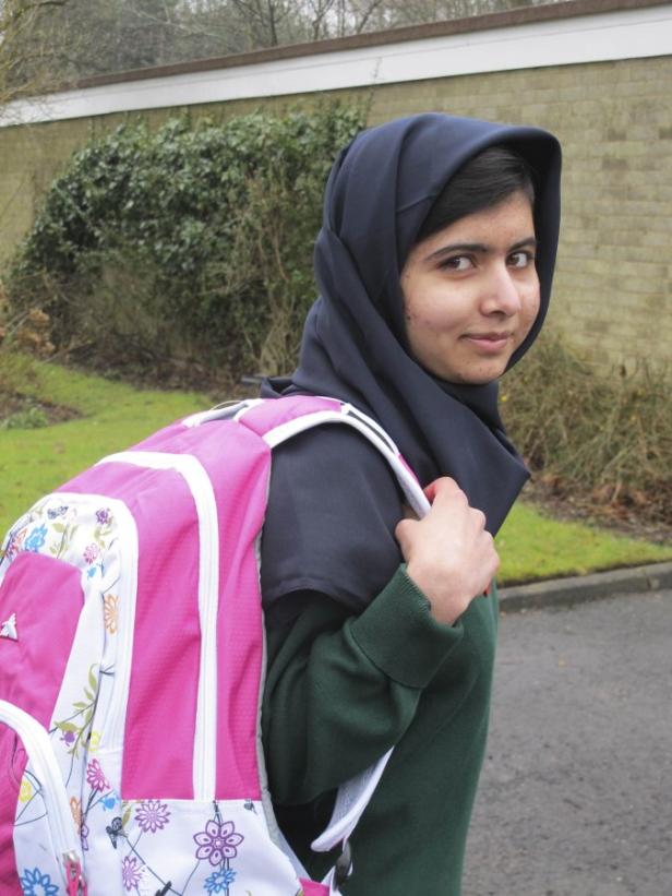 Malala Yousafzai mit einem rosa Rucksack auf dem Weg zur Schule.