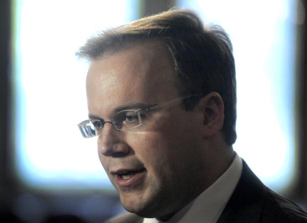 Ein Mann mit Brille und Anzug spricht.