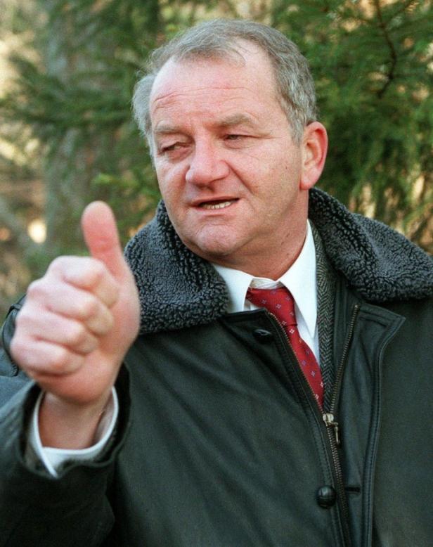 Ein Mann mit Jacke und Krawatte zeigt den Daumen nach oben.