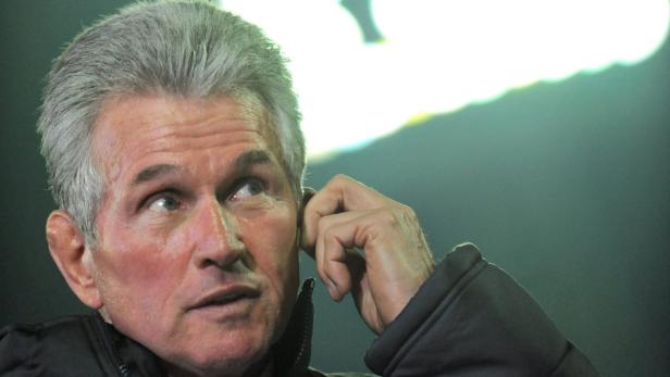 Ein Mann mit grauen Haaren hält sich das Ohr zu.