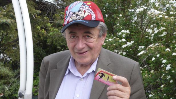 Ein Mann mit Kappe hält eine „Wagner Kind Cup“-Karte in der Hand.