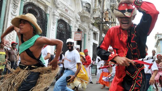 Eine Gruppe von Menschen tanzt während einer Straßenparade in Havanna, Kuba.