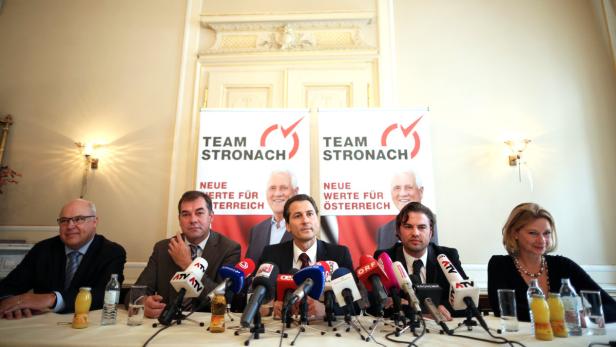Eine Pressekonferenz des Team Stronach mit mehreren Personen hinter einem Tisch mit Mikrofonen.