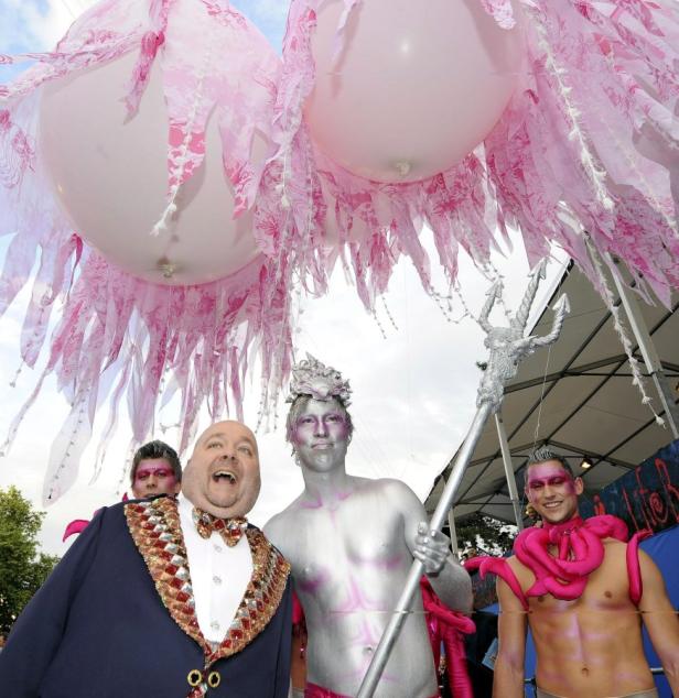 Gruppe von Menschen in fantasievollen Kostümen bei einer Parade oder einem Festival.