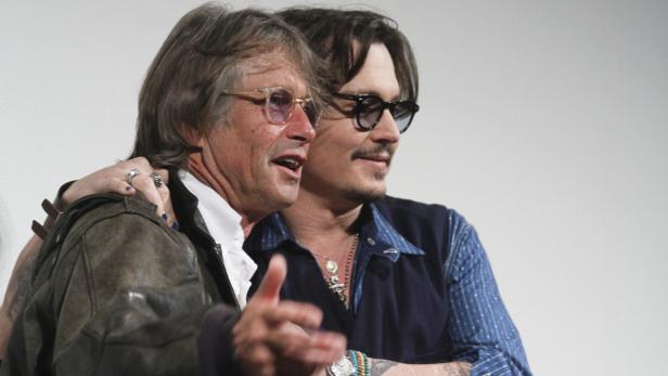 Johnny Depp mit einem älteren Mann, beide lächeln.