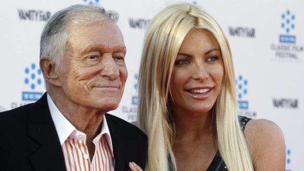 Hugh Hefner und Crystal Harris posieren zusammen auf einem roten Teppich.