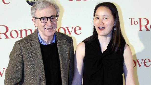 Woody Allen und Soon-Yi Previn posieren vor einem Plakat für „To Rome with Love“.