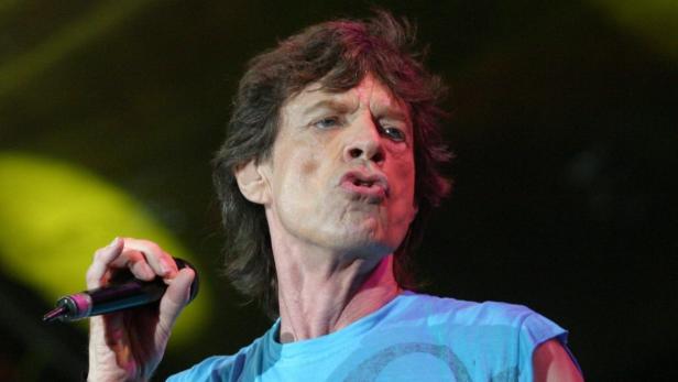 Mick Jagger singt mit einem Mikrofon in der Hand.