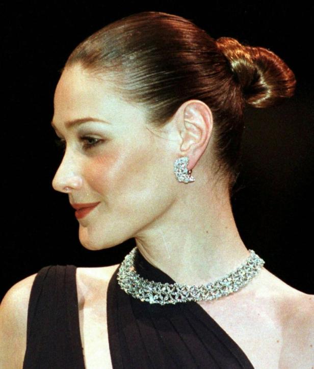 Eine Frau mit hochgesteckten Haaren, Ohrringen und einer Halskette.