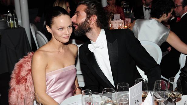 Ein Mann flüstert Vanessa Paradis bei einer formellen Veranstaltung etwas ins Ohr.