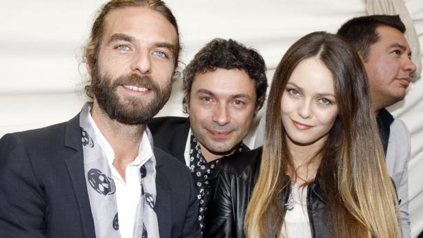 Vanessa Paradis posiert mit zwei Männern für ein Gruppenfoto.