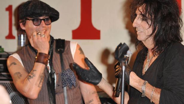 Johnny Depp und Alice Cooper unterhalten sich mit Mikrofonen in der Hand.
