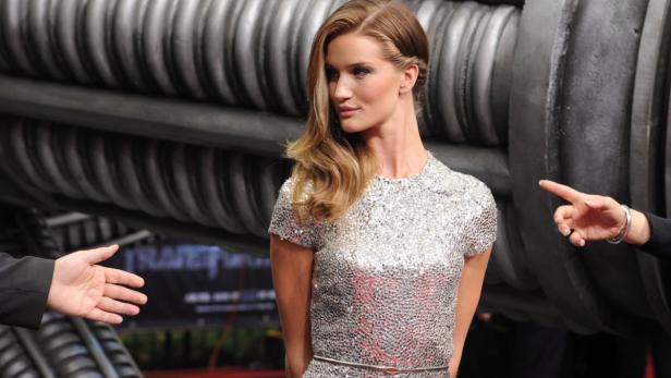 Rosie Huntington-Whiteley posiert vor einem großen mechanischen Gerät.