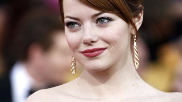 Emma Stone mit roten Lippen und goldenen Ohrringen.