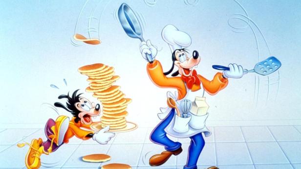 Goofy jongliert mit Pfannkuchen, während Max versucht, einen fallenden Stapel zu retten.