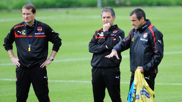 Drei Trainer des österreichischen Fußballteams stehen auf dem Trainingsplatz.