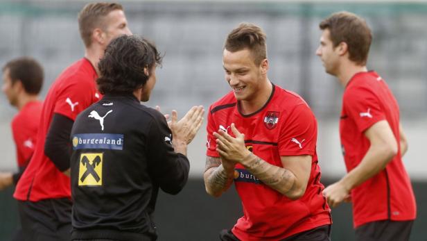 Ein Fußballspieler klatscht mit einem Trainer ab.