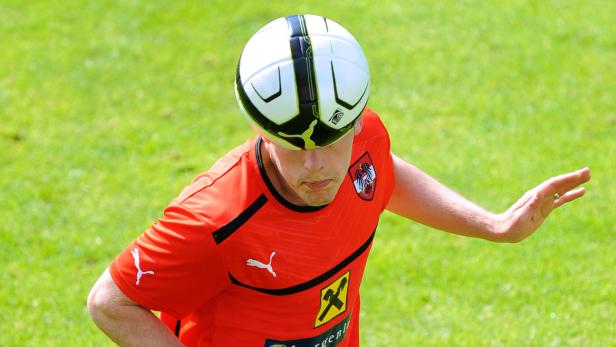 Ein österreichischer Fußballspieler balanciert einen Ball auf der Stirn.