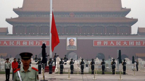 Soldaten stehen auf dem Tiananmen-Platz in Peking vor einem Porträt von Mao Zedong.