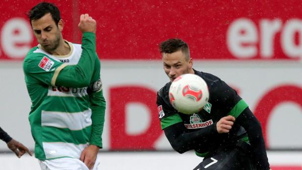 Zwei Fußballspieler während eines Spiels im Regen.