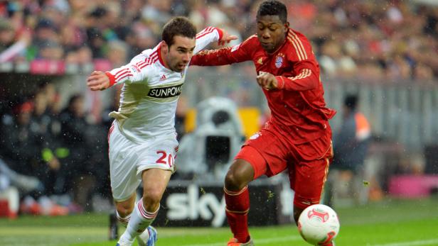 Zwei Fußballspieler kämpfen bei Regen um den Ball.